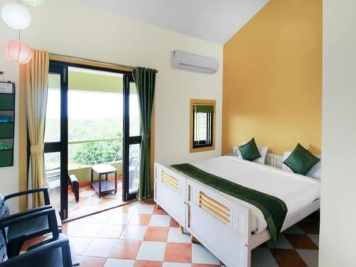 a bedroom with a bed and a large window at Kokanwadi Resort in Ratnagiri