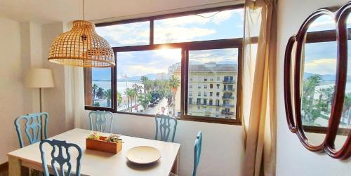 a dining room with a table and chairs and a window at Panoramic views to the sea in Malaga in Málaga