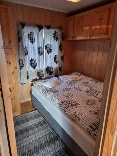 a small bedroom with a bed in a room at fjordRo in Båtsfjord