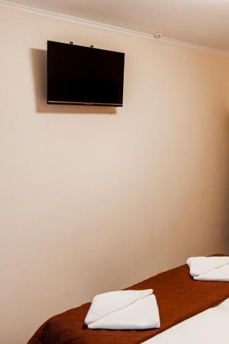 a room with two beds with a flat screen tv on the wall at Tourist Chernivtsi in Chernivtsi