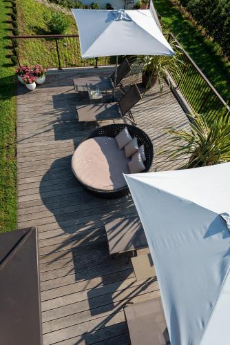 a wooden deck with a table and an umbrella at Hotel und Residence Johanneshof in Cermes