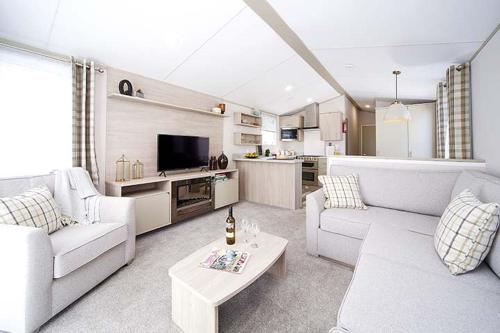 een woonkamer met witte banken en een tv bij Moffat Manor Holiday Park in Beattock