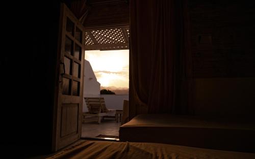 an open door to a bedroom with a view of the ocean at Station House in Dahab