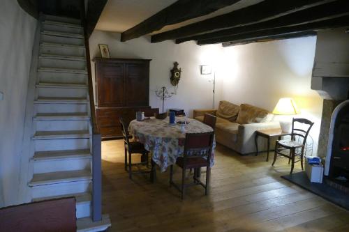 a living room with a table and a couch at L'ancienne ferme in Bujaleuf