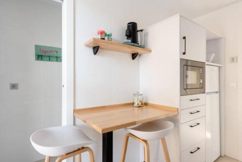 a small kitchen with a desk and two stools at Carmela Suites in Granada