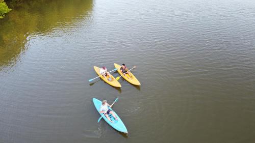 three people are in three kayaks on the water at Marakolliya Beach Resort in Tangalle