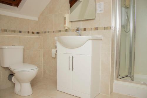 a bathroom with a sink and a toilet and a shower at Ascot Grange Hotel - Voujon Resturant in Leeds