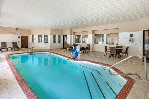 a pool in a hotel with tables and chairs at Comfort Inn & Suites St Louis-O'Fallon in O'Fallon