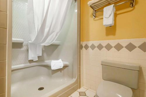 a bathroom with a toilet and a tub and a shower at Quality Inn & Suites Owasso US-169 in Owasso