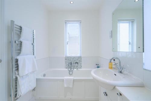 uma casa de banho branca com uma banheira e um lavatório em 39 Rodney House em Cheltenham