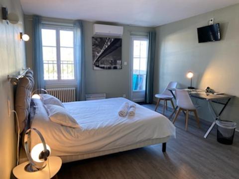 um quarto com uma cama, uma mesa e cadeiras em Relais des Iles chambres d'hôtes em Agen