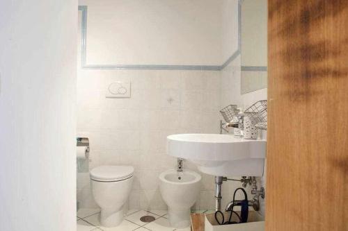 a white bathroom with a sink and a toilet at Donna Saretta Casetta tradizionale Amalfitana in Amalfi