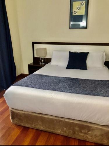 a bedroom with a large bed with a blue pillow at Hotel Excelsior in Lisbon