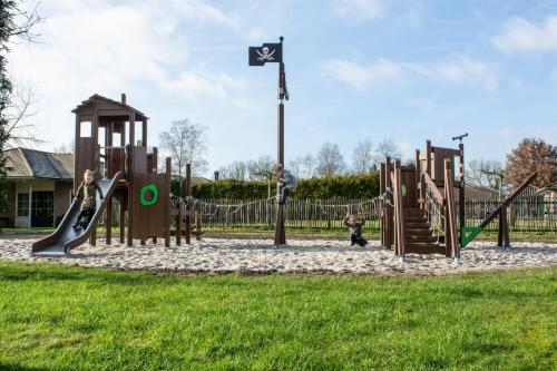 a park with a playground with slides and swings at Recreatiepark De Boshoek in Voorthuizen