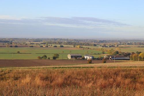 a view of a field with a farm in the distance at The Old Granary in Barnetby le Wold