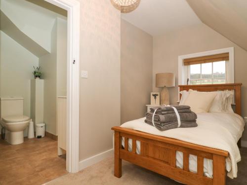 a bedroom with a bed and a toilet at 2 Sandringham Cottages in Brough