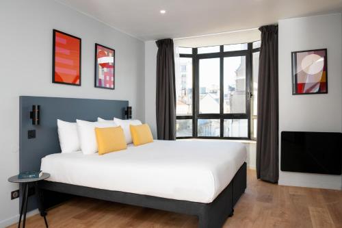a bedroom with a large bed and a large window at Staycity Aparthotels Paris Gare de l'Est in Paris