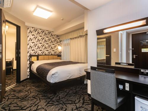 a hotel room with a bed and a mirror at APA Hotel Namba Minami Daikokucho Ekimae in Osaka