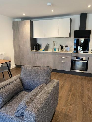 a living room with a couch and a kitchen at Icona - Stylish apartment in brand new development! in York
