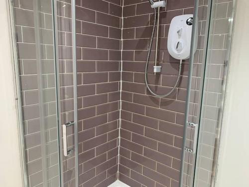 a bathroom with a shower with brown tiles at Huge studio close to city centre with free secure parking in Leeds