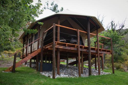 a tree house with a roof on logs at Oakron at Patatsfontein Stay in Montagu