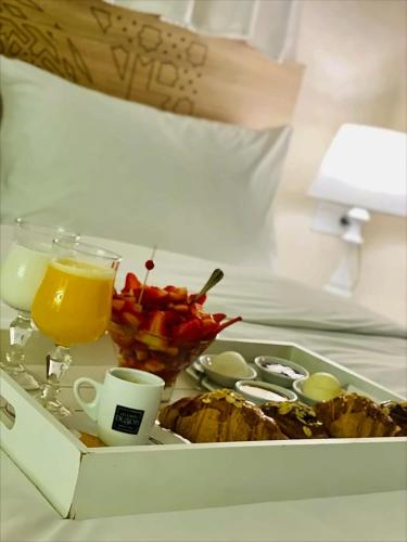a tray of food and a cup of orange juice at Aparthotel & Hotel Doha in Nador
