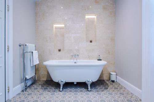 a white bath tub in a bathroom with a tile floor at Cromwell House in Chester