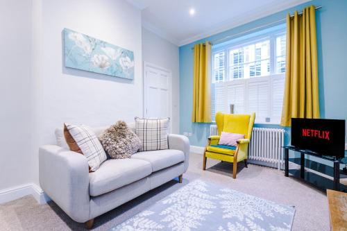 a living room with a couch and a yellow chair at Cromwell House in Chester