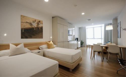 um quarto de hotel com duas camas e uma sala de jantar em MUSH ROOM APARTAMENTOS em Sevilha