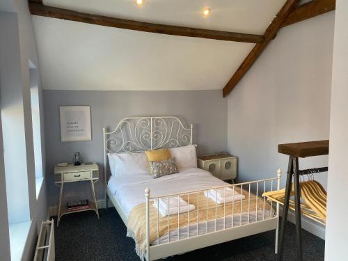 a bedroom with a white bed with a metal headboard at Lovely Coach House with Free Parking in Cardiff
