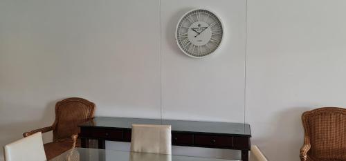 a dining room table with a clock on the wall at UNIT 33 OCEANDUNE in Umhlanga