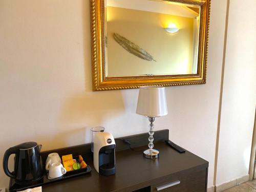 a table with a lamp and a mirror in a hotel room at La Siègià Resort spa in Massa Marittima