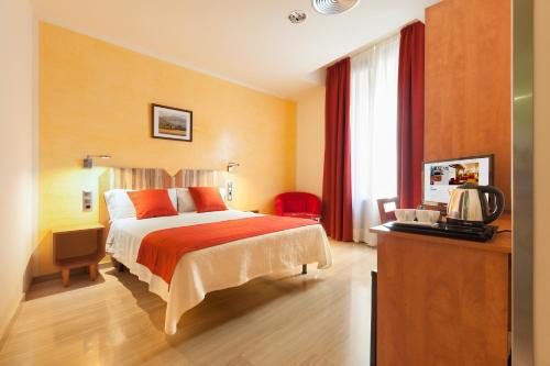 バルセロナにあるアルバ ホテルのベッドとテレビが備わるホテルルームです。