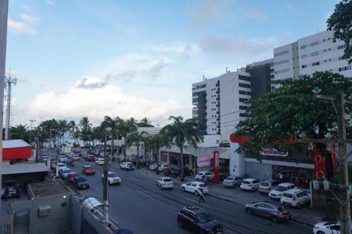 a busy city street with cars parked on the road at Apart Eric Berne Maceió in Maceió