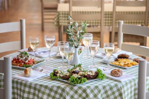 a table with plates of food and glasses of wine at Amalia Hotel Olympia in Olympia