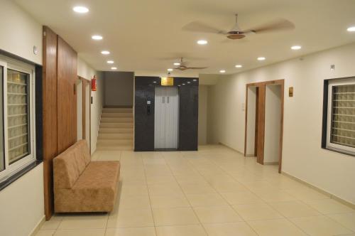 an empty hallway with a chair and a door at Hotel Revive in Veraval