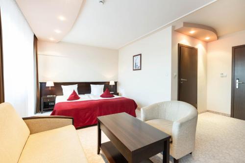 a hotel room with a bed and a table and chairs at Hotel Kudowa Manufaktura Relaksu in Kudowa-Zdrój