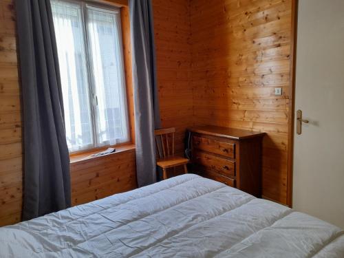 une chambre avec un lit, une commode et une fenêtre dans l'établissement Agréable appartement de 48 m² en RDC, à La Bourboule