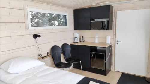 a room with a bed and a desk and a microwave at Loma Luonnonlapsi Tuli-mökki in Sotkamo