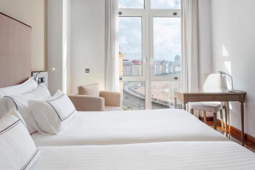um quarto de hotel com duas camas e uma grande janela em Melia Maria Pita em La Coruña