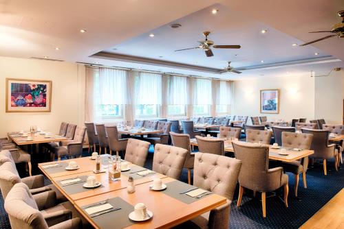 una sala da pranzo con tavoli e sedie di Taste Hotel Kulmbach a Kulmbach