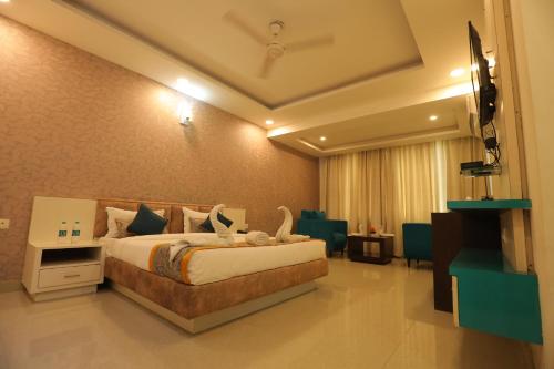 a hotel room with a bed and a television at Meera Madhav Resort in Vrindāvan