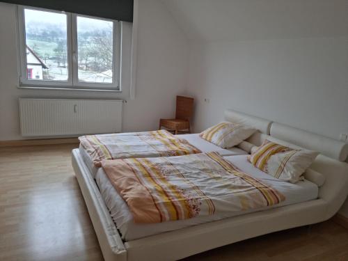 GammelshausenにあるFerienwohnung Cavallino Gammelshausenの窓付きの客室の白いベッド1台