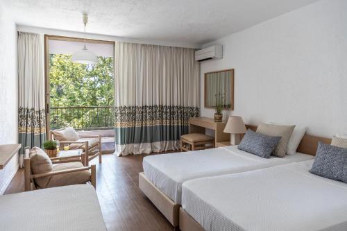 オリンピアにあるAmalia Hotel Olympiaのベッド2台とバルコニーが備わるホテルルームです。