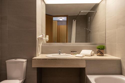 a bathroom with a sink and a toilet and a mirror at Amalia Hotel Olympia in Olympia