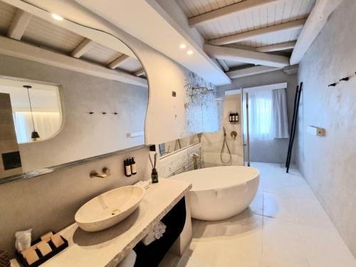 a bathroom with a large white tub and a sink at Hotel delle Rose in Porto Cervo