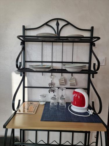 a table with a shelf with plates and dishes on it at Viktória Inn Tihany in Tihany