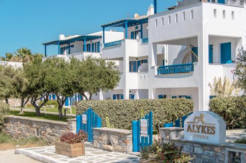 un edificio blanco con un cartel delante en Alykes Studios & Suites, en Agios Prokopios