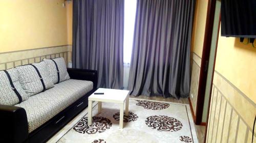 a living room with a couch and a table at Квартира 5-9 in Aktau