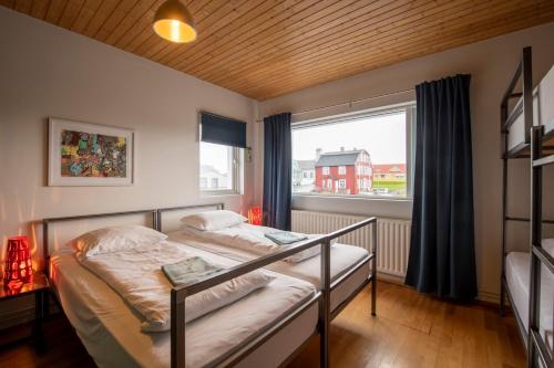 a bedroom with a bed and a large window at Sjávarborg in Stykkishólmur